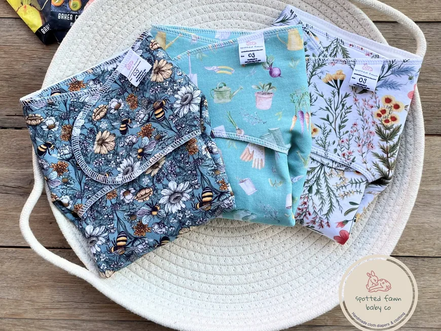 Printed bamboo preflats in bee, floral and blue prints in a woven rope basket